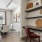 a room with a table chairs and a shelf with art on it